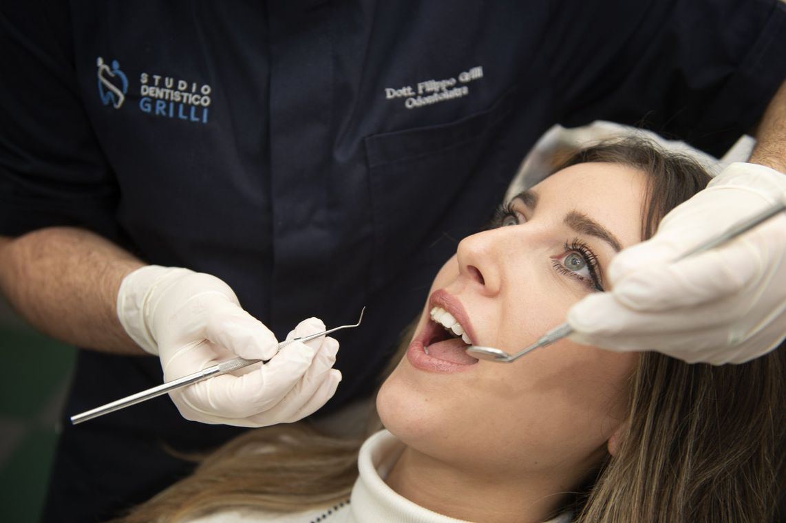 Una paziente durante una visita, con gli strumenti del dentista