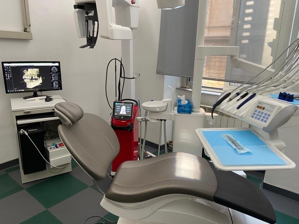 Una sala di cura dello studio: poltrona, monitor con la scansione 3D, apparecchio radiologico e strumenti